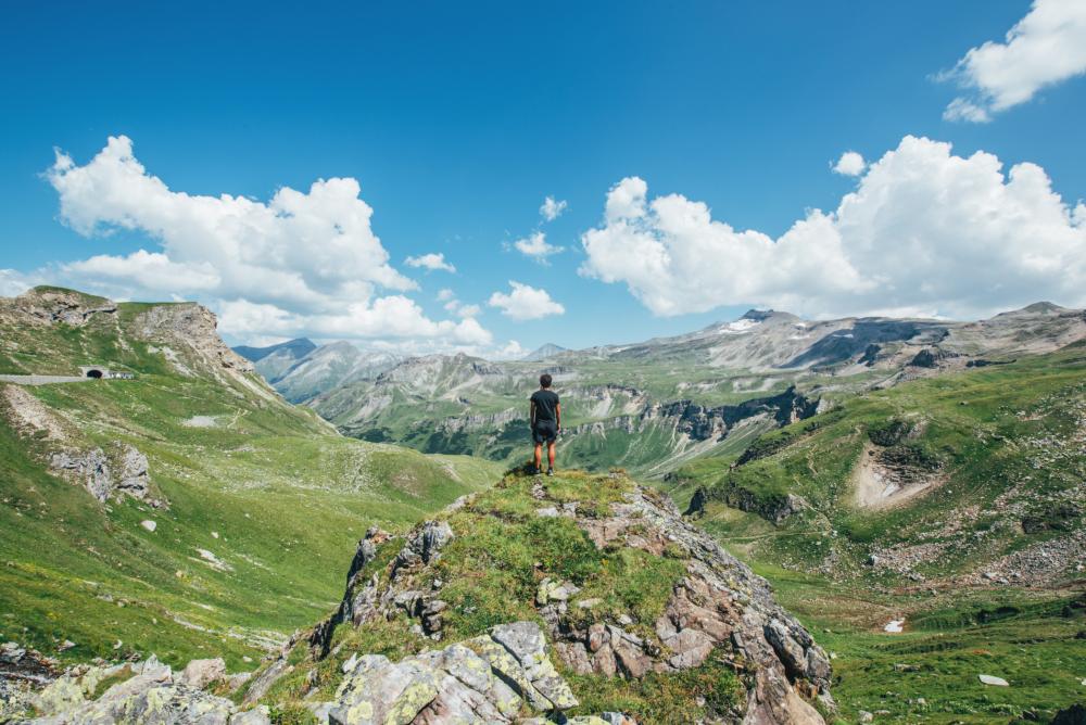 Homme regardant le ciel et les montagnes en été